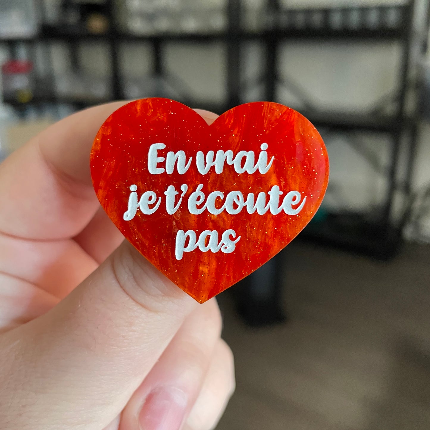 Broche "En vrai je t'écoute pas" en acrylique marbrée orange à paillettes