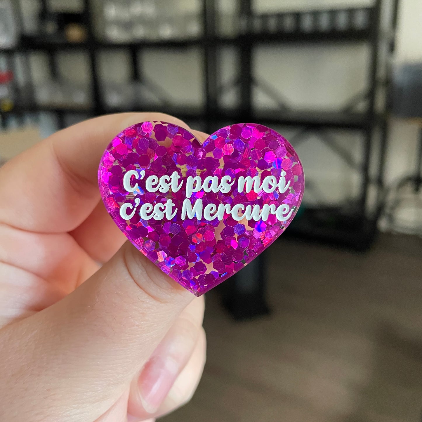 Broche "C'est pas moi c'est Mercure" en acrylique semi transparente avec des confettis fuchsia