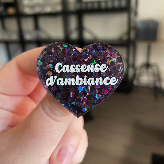 Broche "Casseuse d'ambiance" en acrylique semi transparente avec des confettis noirs