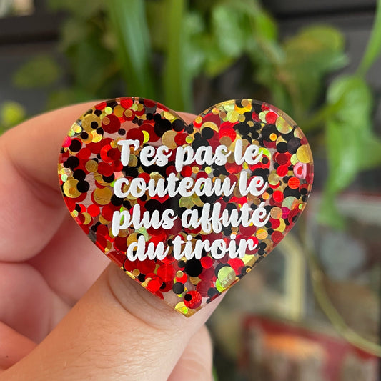 Broche "T'es pas le couteau le plus affuté du tiroir" en acrylique semi-transparente avec des pois rouges, jaunes et noirs