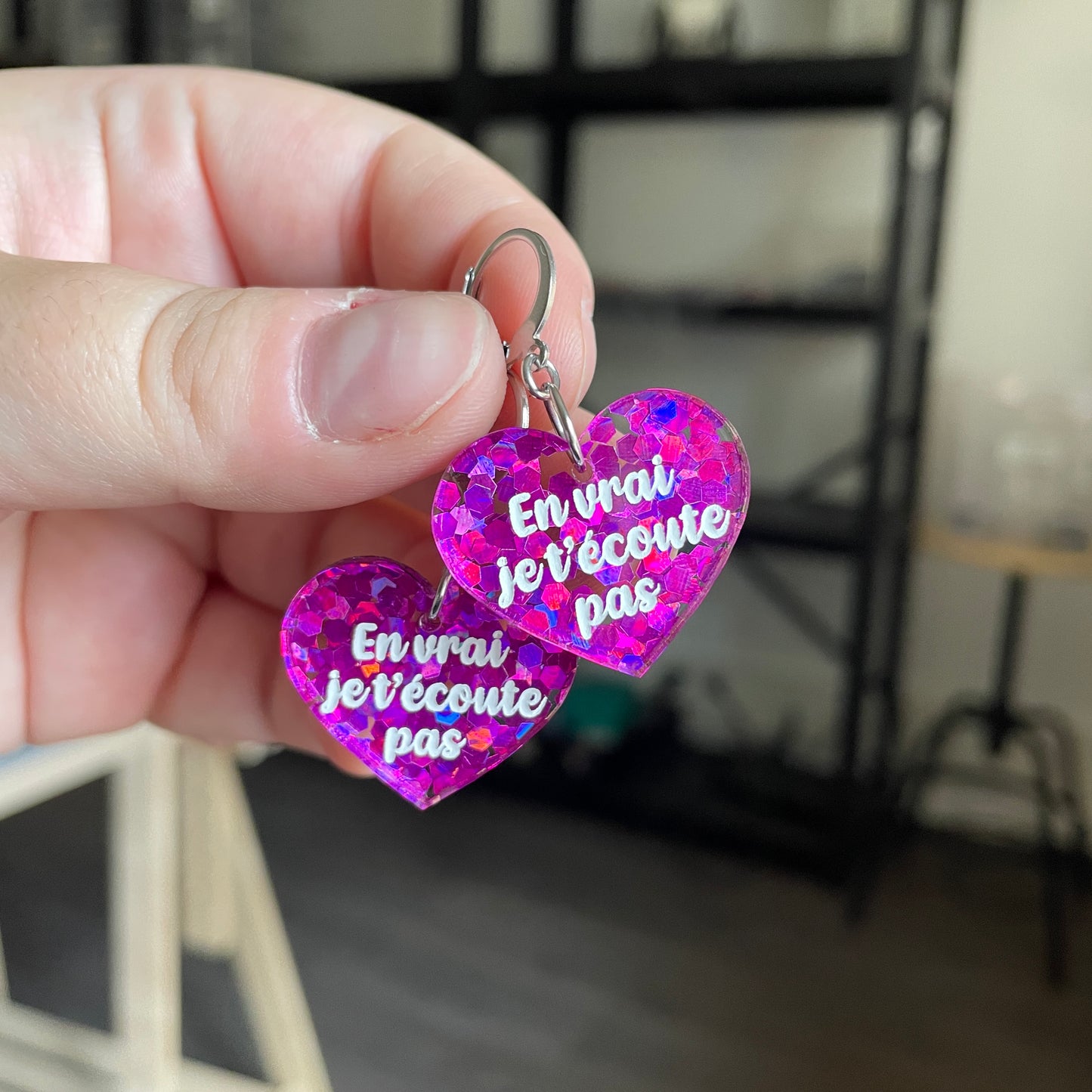 Petites boucles d'oreilles coeurs pendantes "En vrai je t'écoute pas" en acrylique semi transparente avec des confettis fuchsia