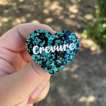Broche "Crevure" en acrylique noire à confettis galactiques turquoise