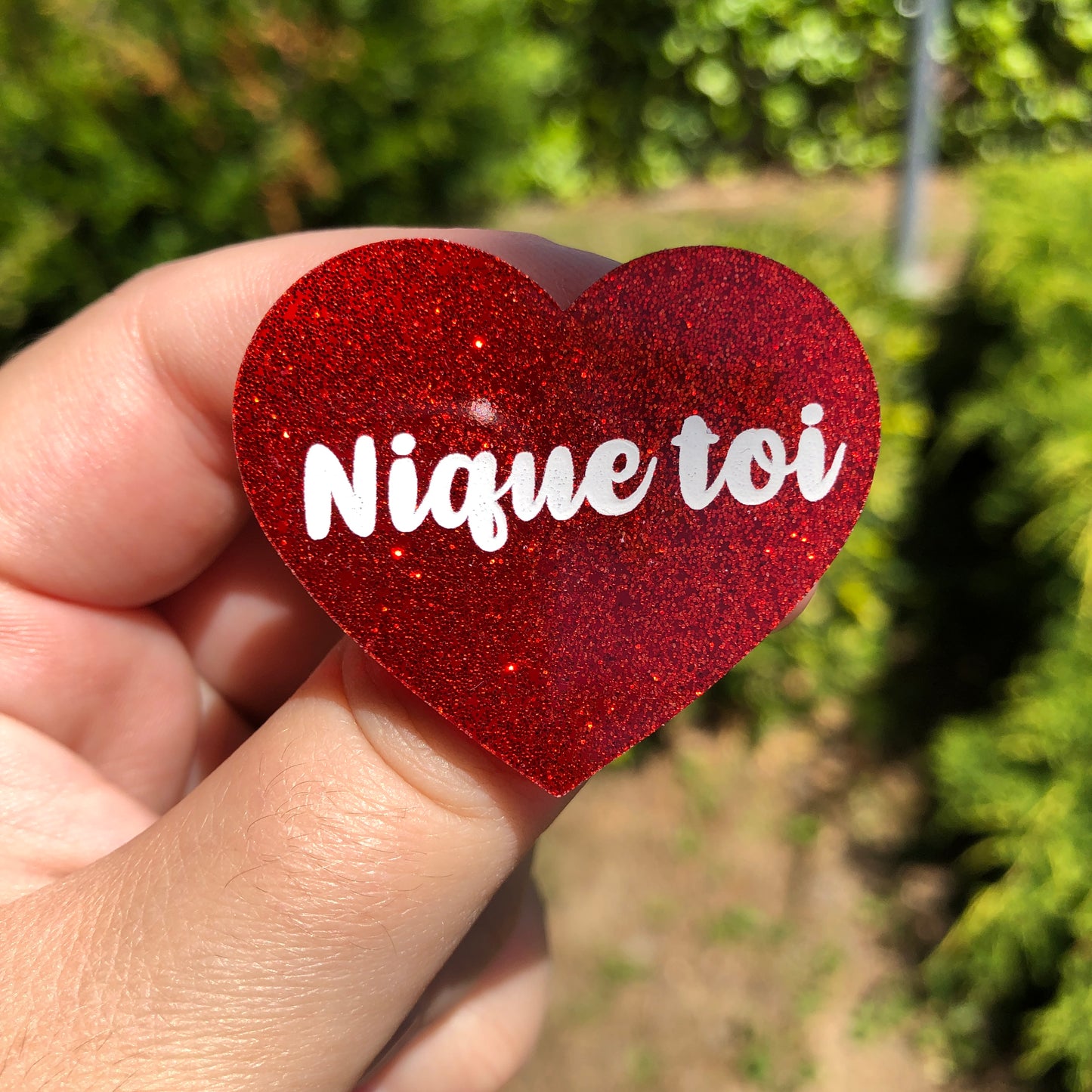 Broche "Nique toi" en acrylique à paillettes rouges