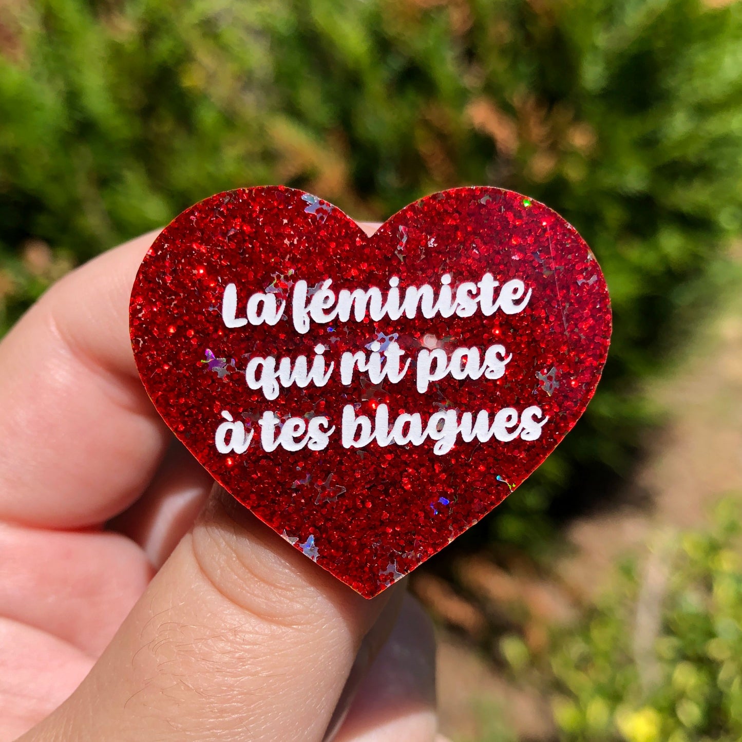 Broche "La féministe qui rit pas à tes blagues" en acrylique à paillettes rouges et étoiles