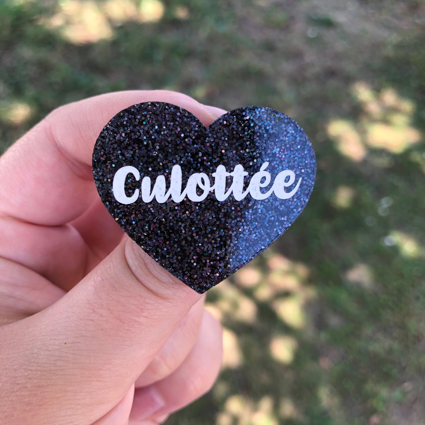 Broche "Culottée" en acrylique à paillettes noires holographiques