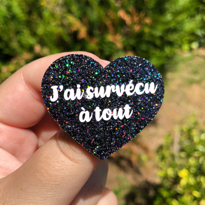 Broche "J'ai survécu à tout" en acrylique à paillettes noires holographiques