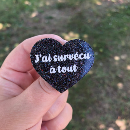 Broche "J'ai survécu à tout" en acrylique à paillettes noires holographiques