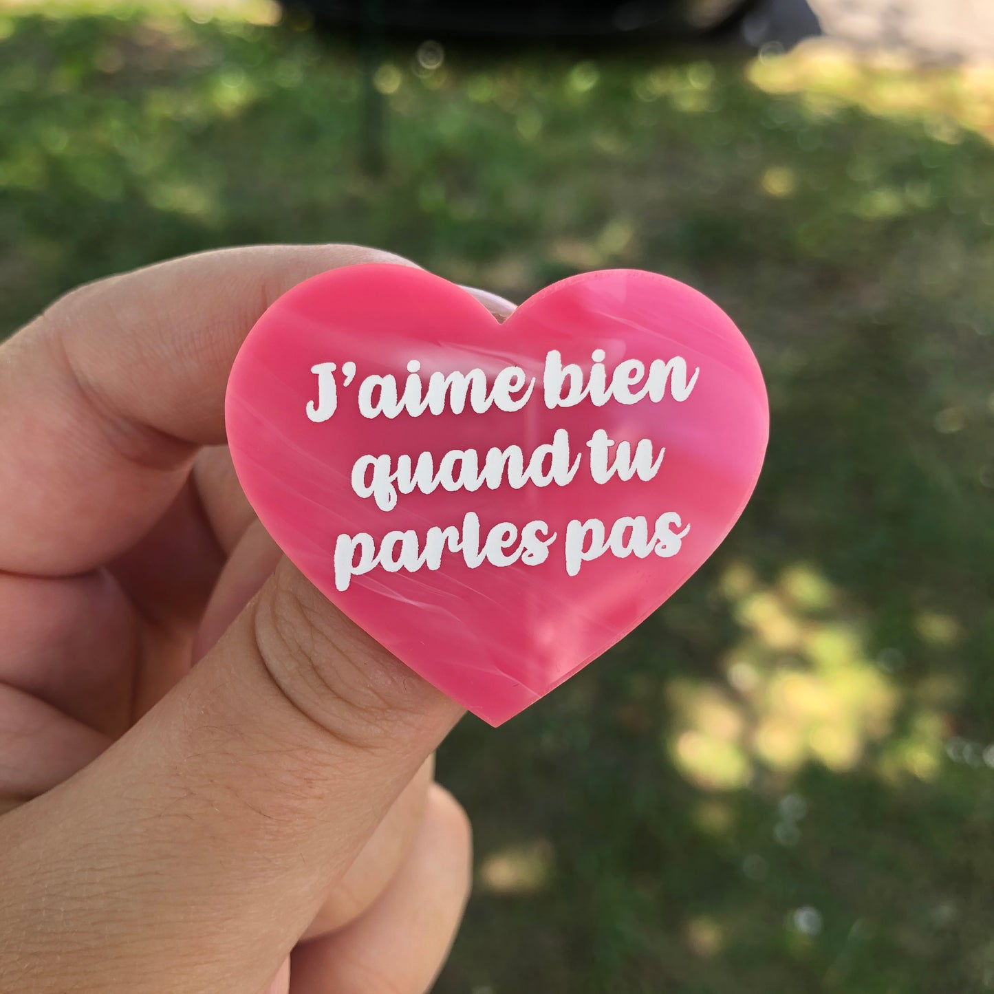 Broche "J'aime bien quand tu parles pas" en acrylique marbrée rose et blanche