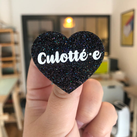 [Inclusif] Broche "Culotté.e" en acrylique à paillettes noires