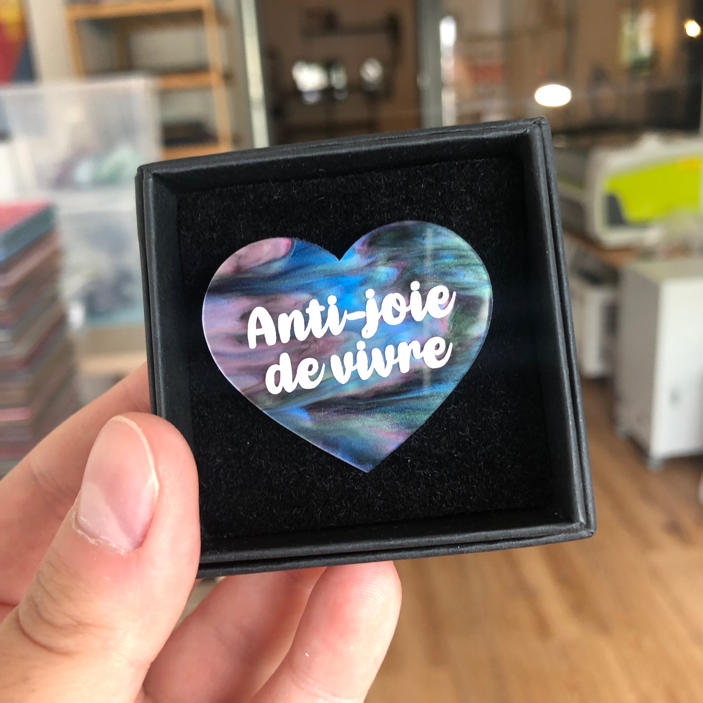 Broche "Anti joie de vivre" en acrylique marbrée vert, bleu, noir et rose