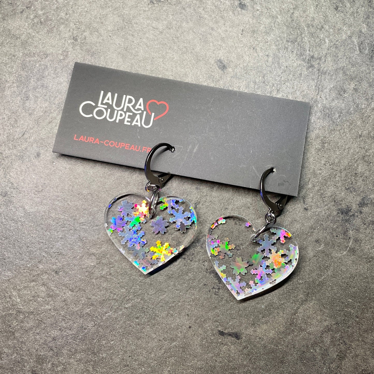 Petites boucles d'oreilles coeurs pendantes en acrylique transparente avec des confettis flocons holographiques