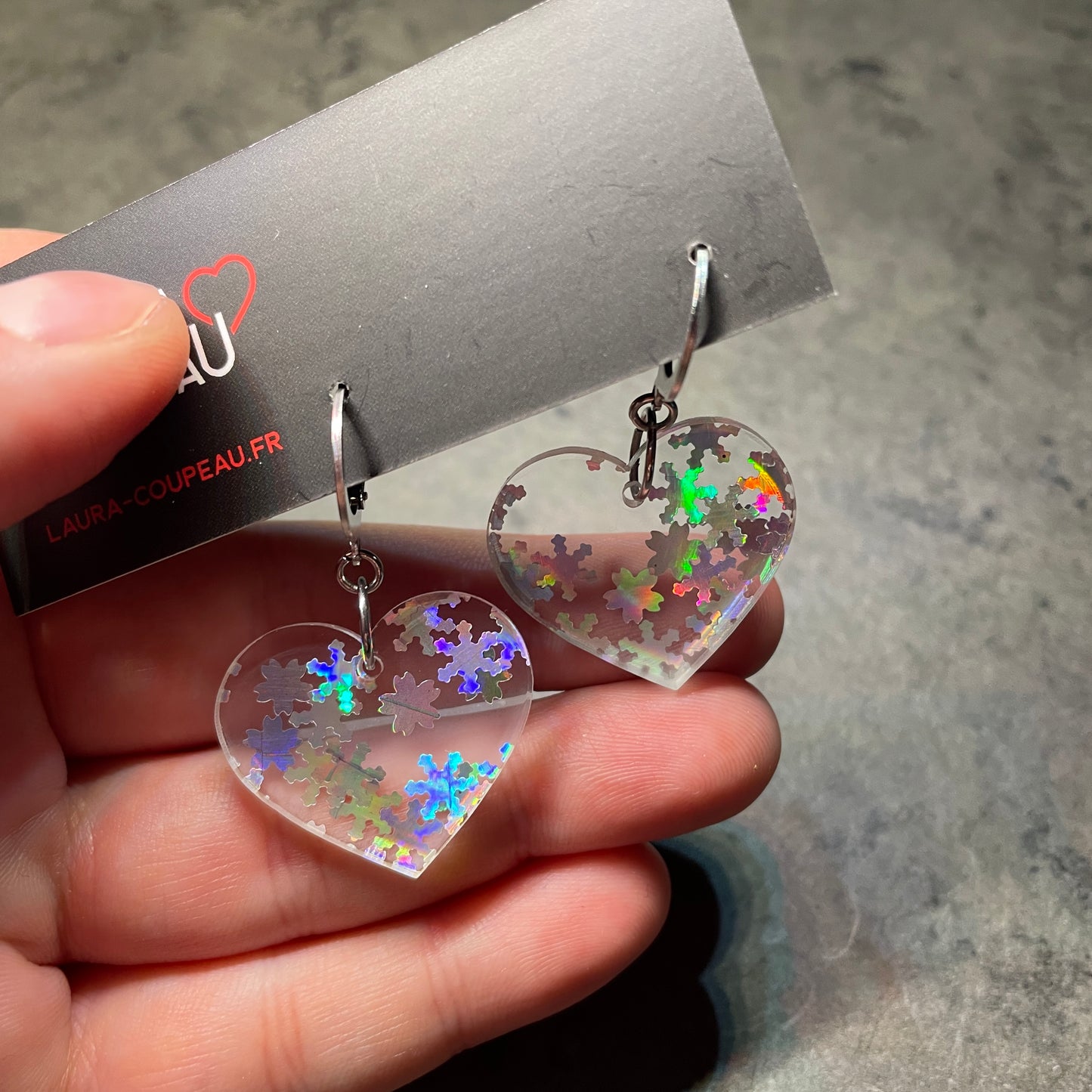 Petites boucles d'oreilles coeurs pendantes en acrylique transparente avec des confettis flocons holographiques