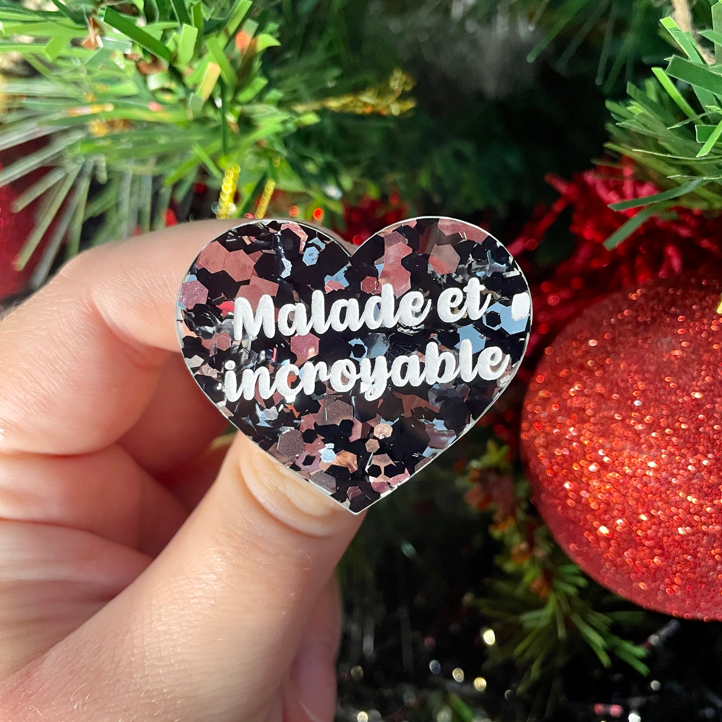 Broche "Malade et incroyable" en acrylique transparente à gros confettis noirs et argentés