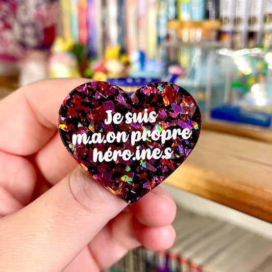 [INCLUSIF] Broche "Je suis m.a.on propre héroi.ne.s" en acrylique à gros confettis rouges et roses holographiques sur fond noir