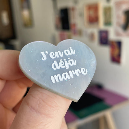 Broche "J'en ai déjà marre" en acrylique marbrée nacrée blanche et bleutée à paillettes
