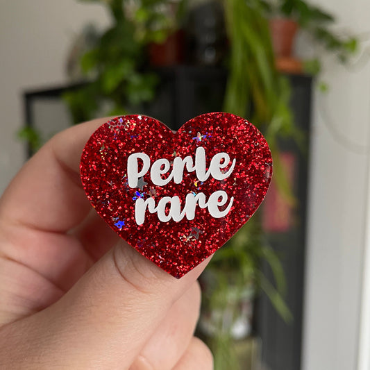 Broche "Perle rare" en acrylique rouge à paillettes avec des étoiles