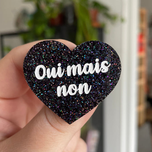 Broche "Oui mais non" en acrylique noire à paillettes holographiques