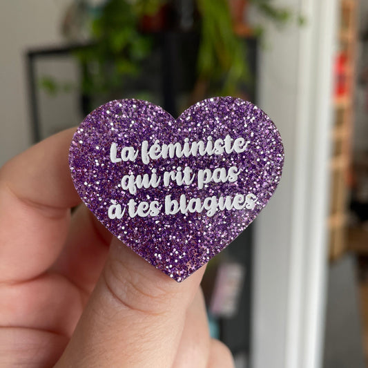 Broche "La féministe qui rit pas à tes blagues" en acrylique violette à paillettes