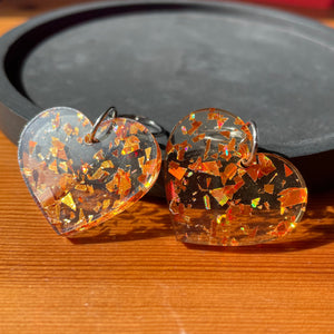Petites boucles d'oreilles coeurs pendantes en acrylique transparente avec des éclats de confettis oranges