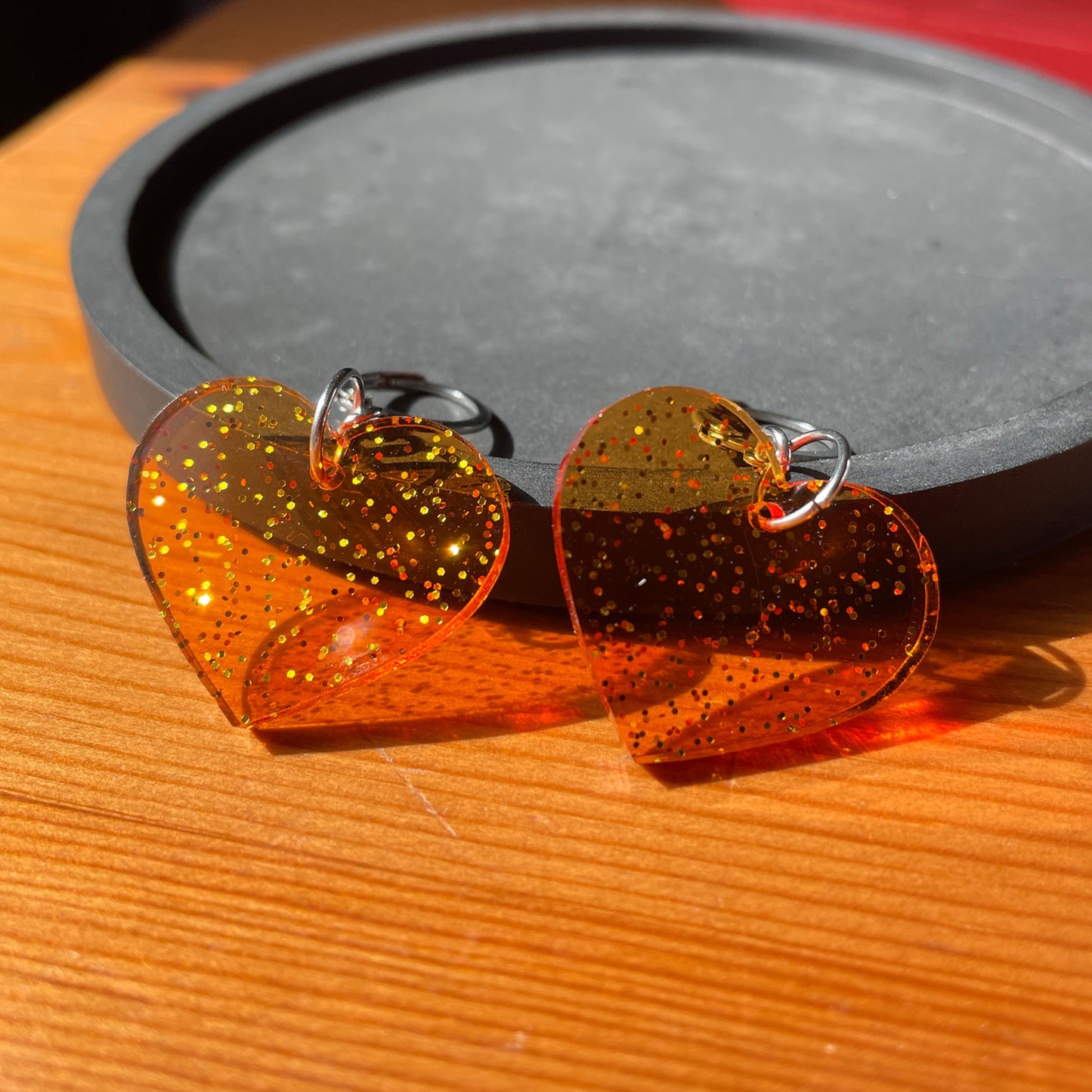 Petites boucles d'oreilles coeurs pendantes en acrylique transparente orange à paillettes