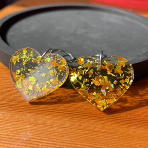 Petites boucles d'oreilles coeurs pendantes en acrylique transparente avec des éclats de confettis dorés