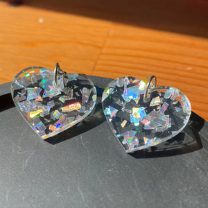 Petites boucles d'oreilles coeurs pendantes en acrylique transparente avec des éclats de confettis argentés