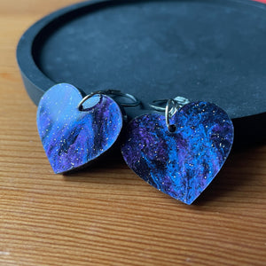 Petites boucles d'oreilles coeurs pendantes en acrylique marbrée galactique noire et violette à paillettes