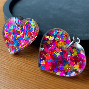 Petites boucles d'oreilles coeurs pendantes en acrylique avec des confettis étoiles et lunes multicolores