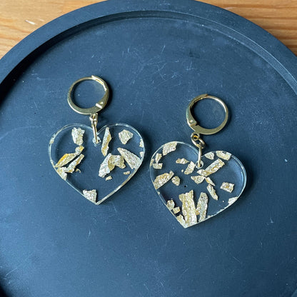 Petites boucles d'oreilles coeurs pendantes en acrylique transparente avec des éclats de feuilles dorées