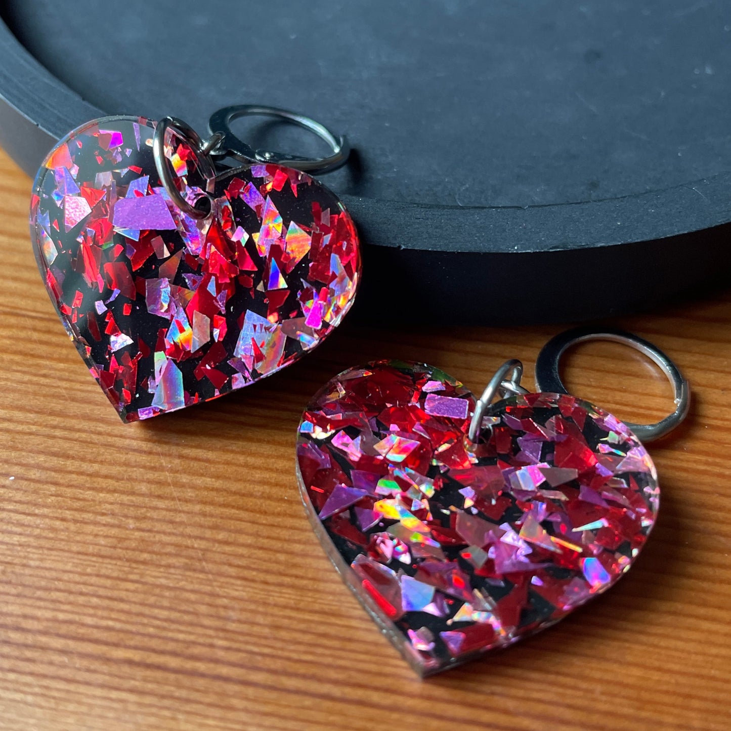 Petites boucles d'oreilles coeurs pendantes en acrylique noire avec des confettis galactiques rouges et roses