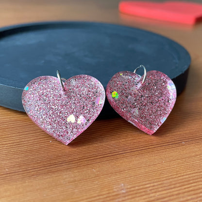 Petites boucles d'oreilles coeurs pendantes en acrylique pailletée rose avec des coeurs