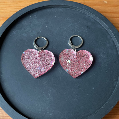 Petites boucles d'oreilles coeurs pendantes en acrylique pailletée rose avec des coeurs