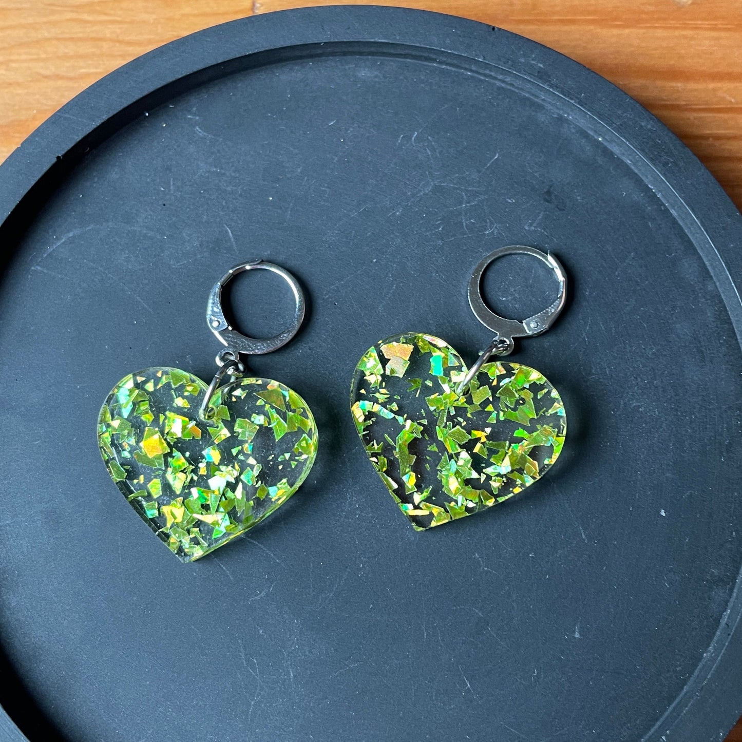 Petites boucles d'oreilles coeurs pendantes en acrylique transparente avec des éclats de confettis jaunes/verts