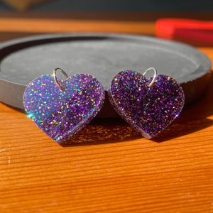 Petites boucles d'oreilles coeurs pendantes en acrylique à paillettes violettes (et un peu de jaune et de bleu)