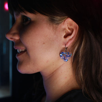 Petites boucles d'oreilles coeurs pendantes en acrylique transparente avec des éclats de confettis bleus