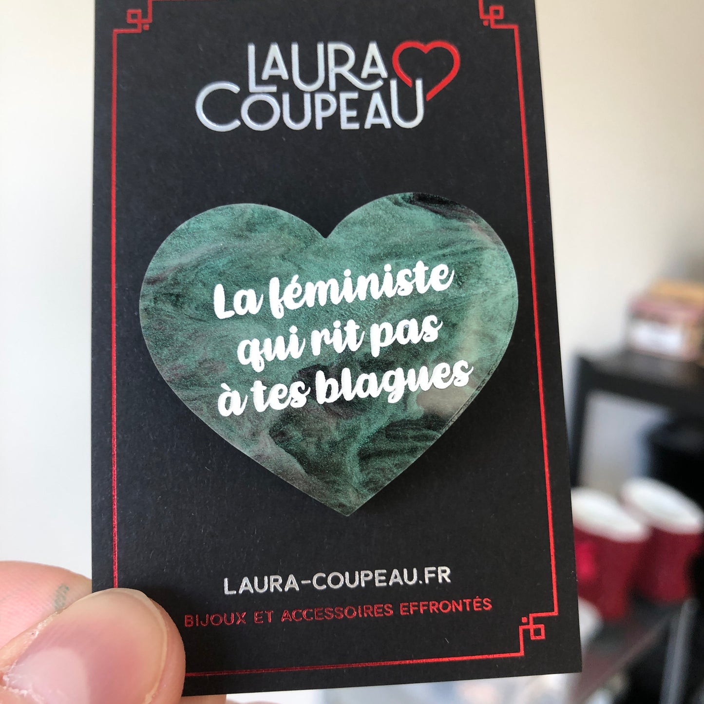 Broche "La féministe qui rit pas à tes blagues" en acrylique marbrée verte, noire et rose/violette