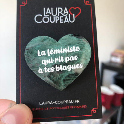 Broche "La féministe qui rit pas à tes blagues" en acrylique marbrée verte, noire et rose/violette